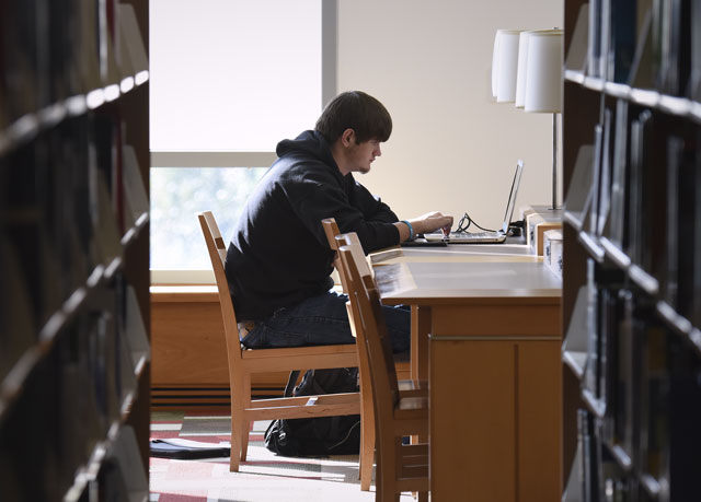 {A male student studies in a library}