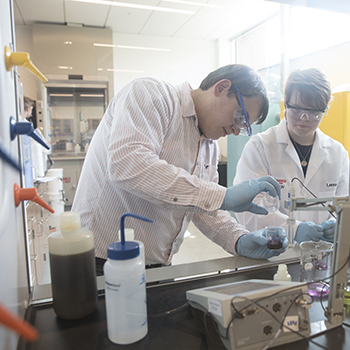 Professor and student filling beakers as part of an experiment in Hudson Lab Sciences Building
