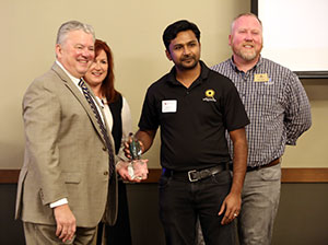 President McAlexander is presented an award at the Early Bird Breakfast