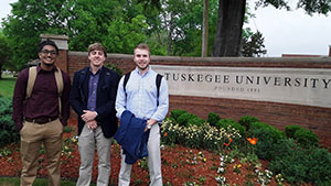 Political science majors stand next to the entrance for Tuskegee University