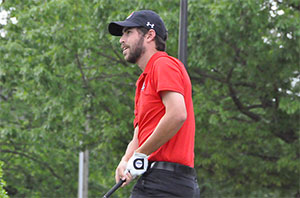 Golf player watches the ball after teeing off