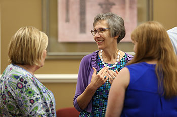 Charlene Baxter speaks with friends during her retirement party
