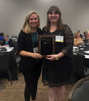 Caroline Stinson, right, stands with professor Kelly Veal after receiving the student counselor of the year award.