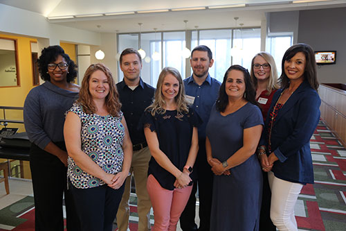 New faculty lined up in two rows in the library