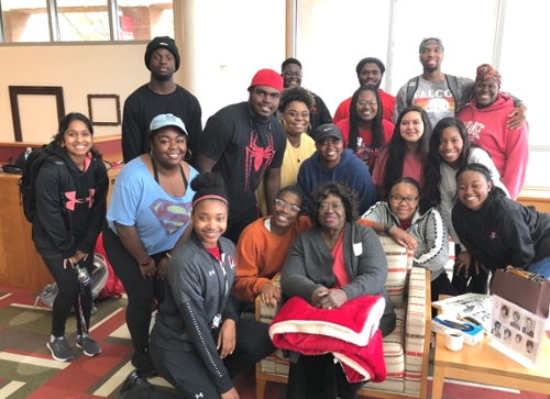 Mrs. Verona Hill (center) poses with a group of students in the library after her Homecoming talk