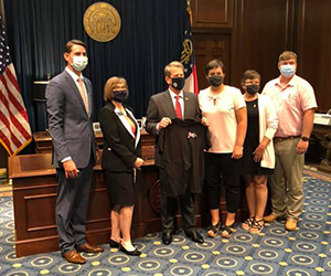 Georgia Governor Brian Kemp pauses with Lacee and her family after signing the bill into law