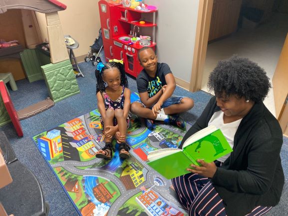 Kiara Tookes-Williams reads a story to a staff member's children
