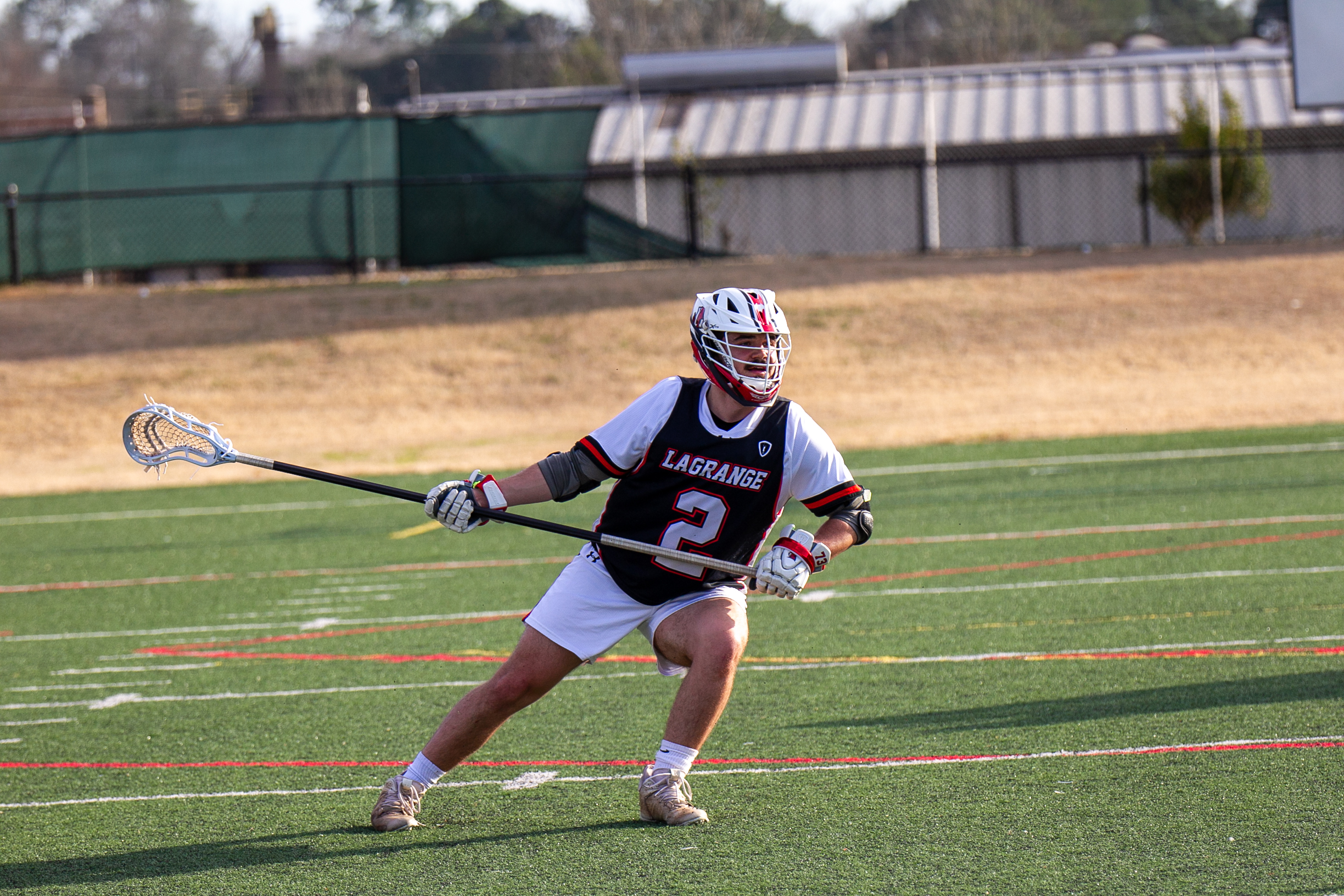 Student running across lacrosse field