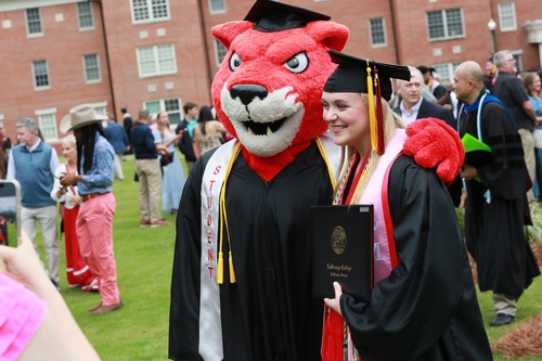 Graduate poses with mascot