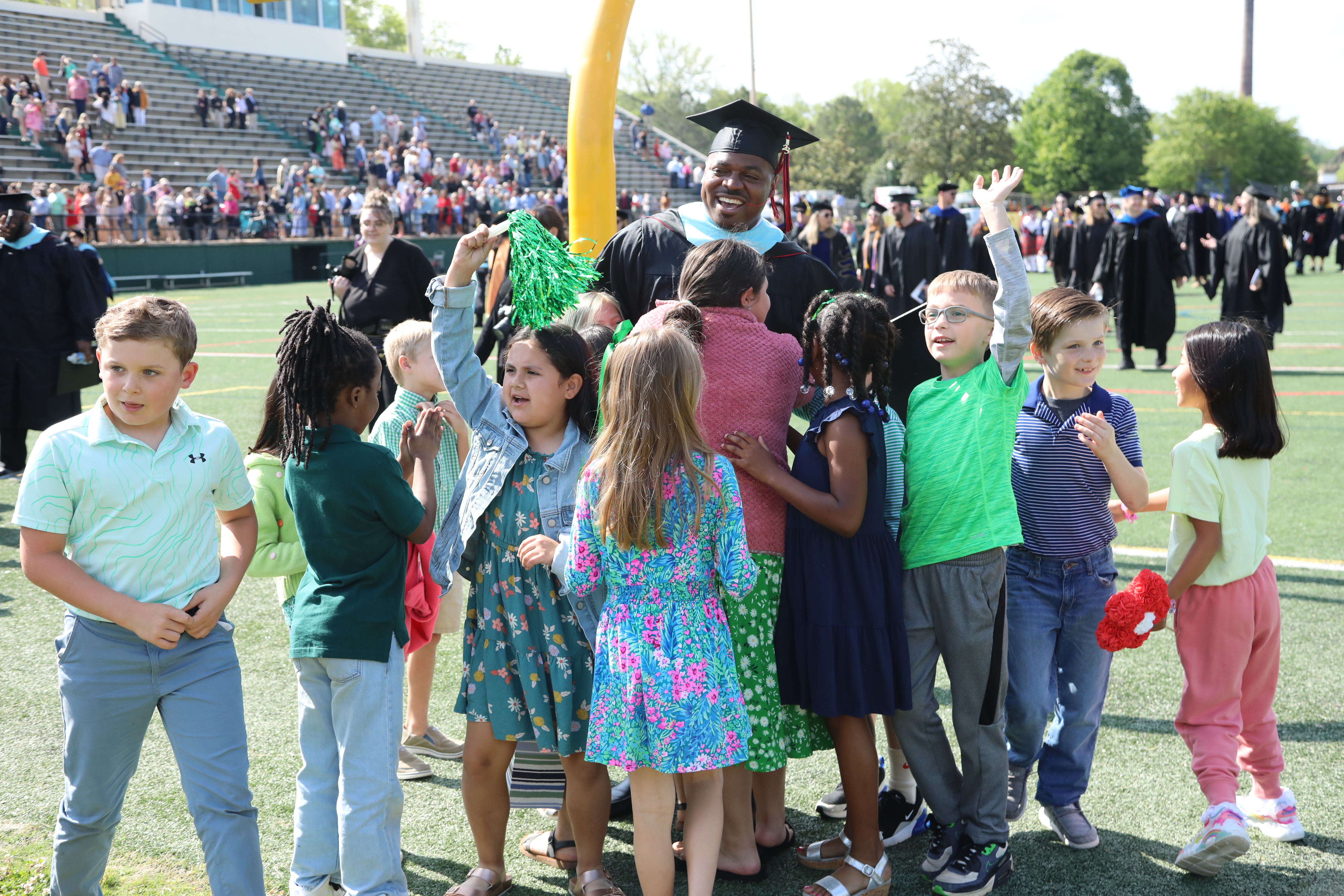 Education graduate poses with students