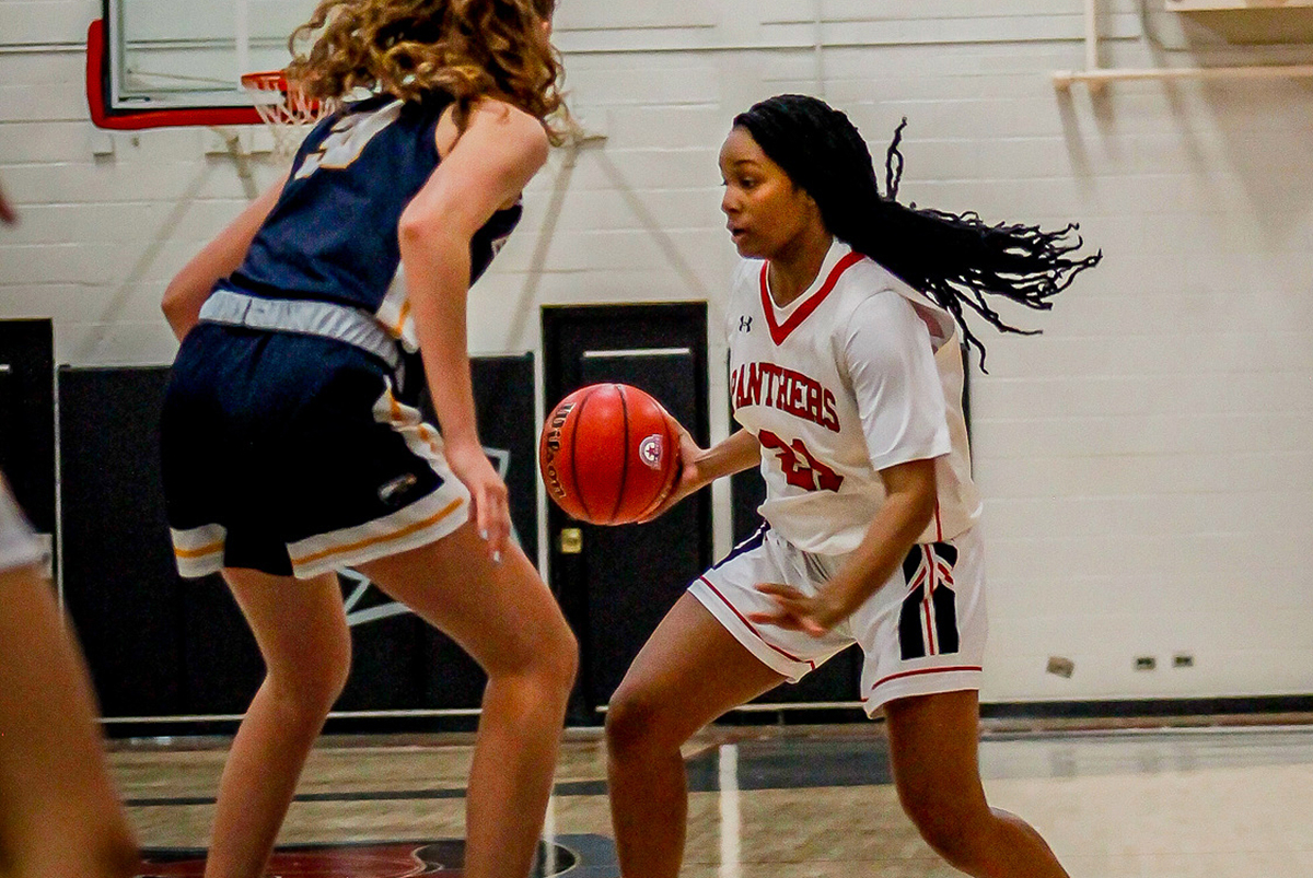 Woman competing in basketball game