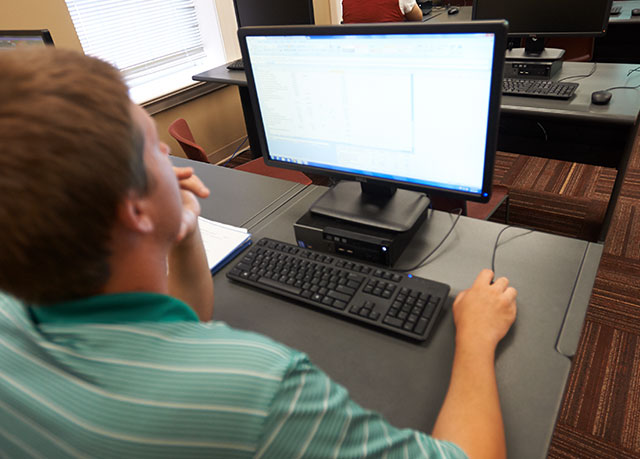 A student sits at a laptop