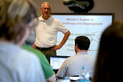 Professor Tom Thomsen speaks with a Philanthropy and Development cohort in a classroom