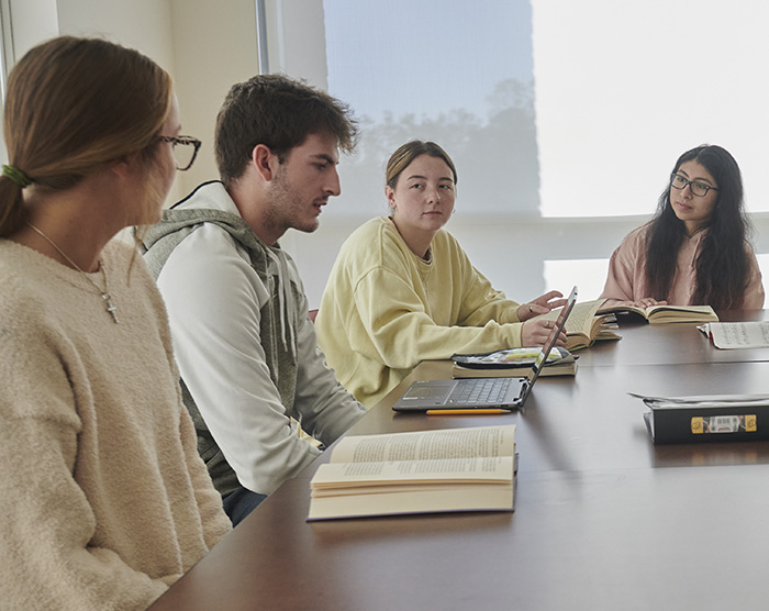 A group of students work at a table in the library