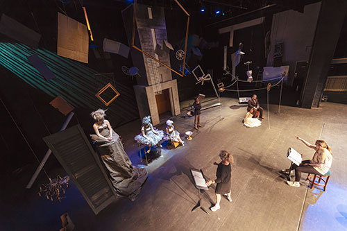 An overview of the theater stage with a full cast in practice
