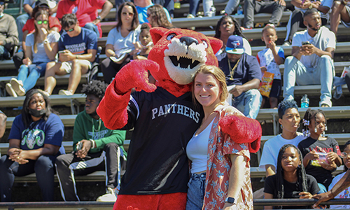 Pouncer the mascot pauses with a fan in the stands during a LaGrange College football game.