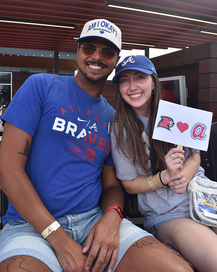 A boy and girl smiling at the camera sporting Braves gear