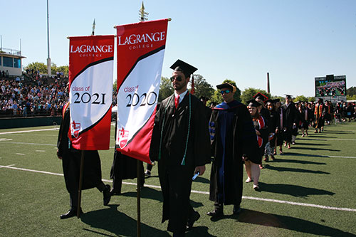 Commencement march - two men carry banners to lead both classes in