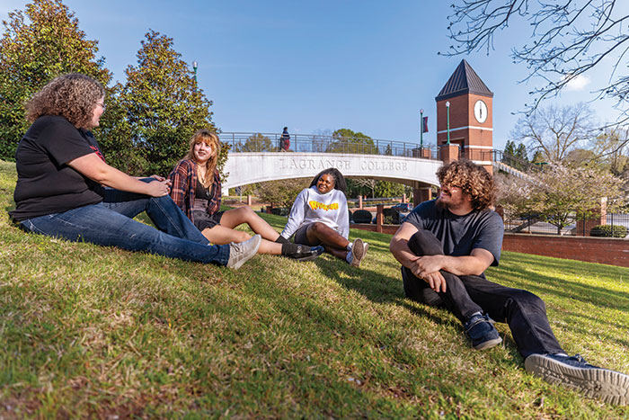 Four students sit on a hill