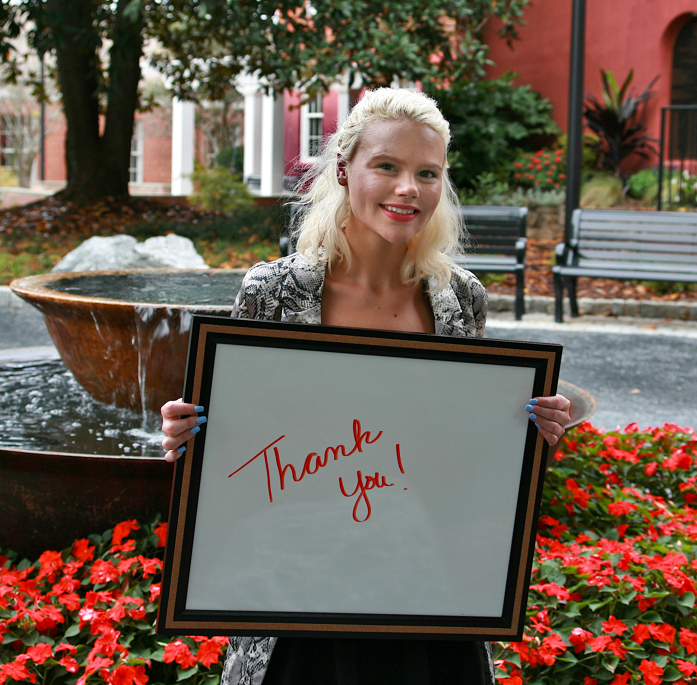 Young female adult holding a sign that says "Thank you!"